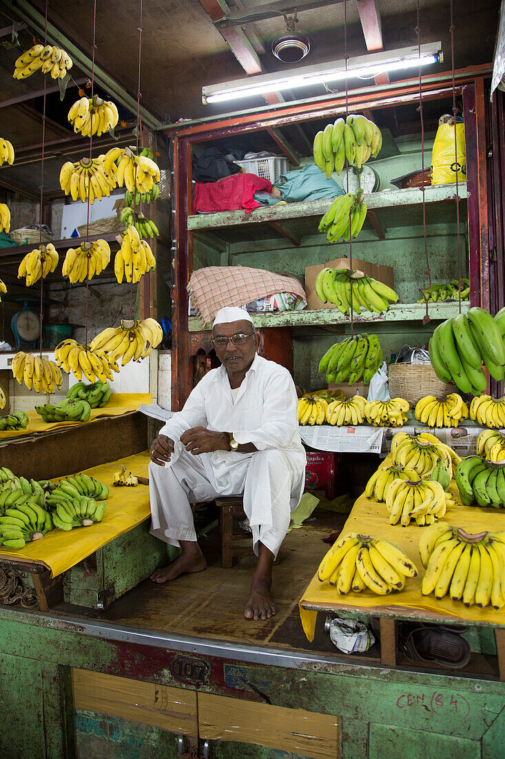 Man sells bananas at fruit stand at Mahatma Jyotiba Phule Market (Crawford Market), Mumbai, Maharashtra, India