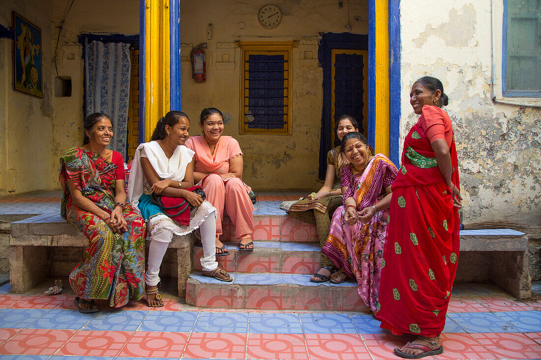 Cheerful women in colorful dresses outside school building, Porbandar, Gujarat, India