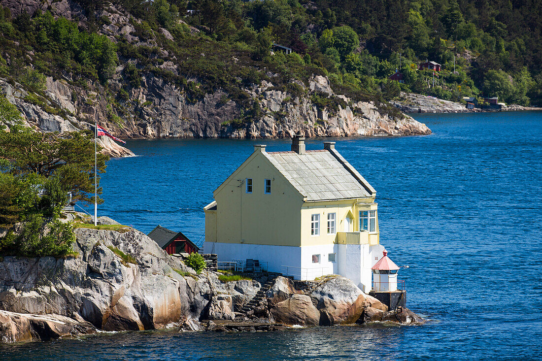 Yellow wooden house in fjord, near Bergen, Hordaland, Norway