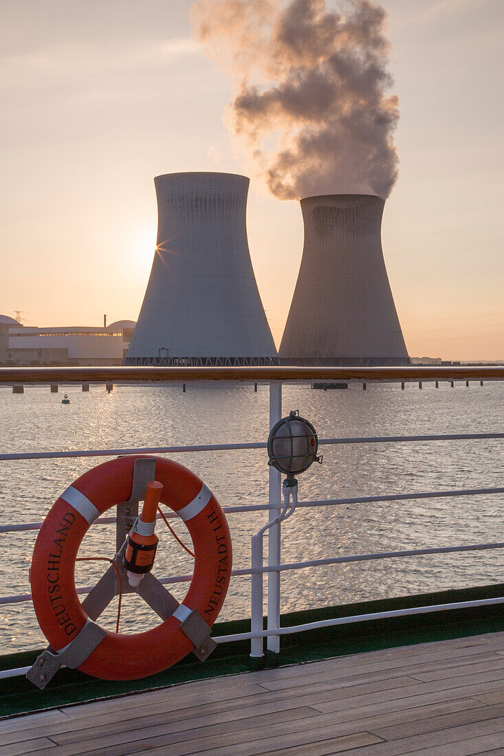 Rettungsring und Reling von Kreuzfahrtschiff MS Deutschland (Reederei Peter Deilmann) vor dem Atomkraftwerk Doel am Fluss Schelde bei Sonnenuntergang, Antwerpen, Flandern, Belgien, Europa