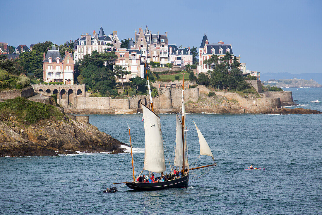 Excursion sailboat La Cancalaise (replica of 1905 French cutter Le Perle) during sailing excursion in Saint-Malo Bay with Dinard coastline behind, Dinard, Brittany, France