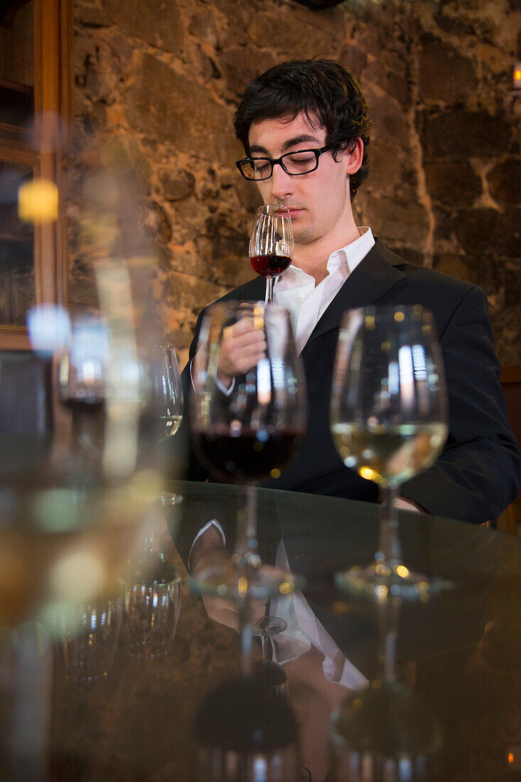 Eleganter Mann riecht am Portwein während einer Weinprobe im Keller des Weinguts Burmester, Porto, Norte, Portugal, Europa