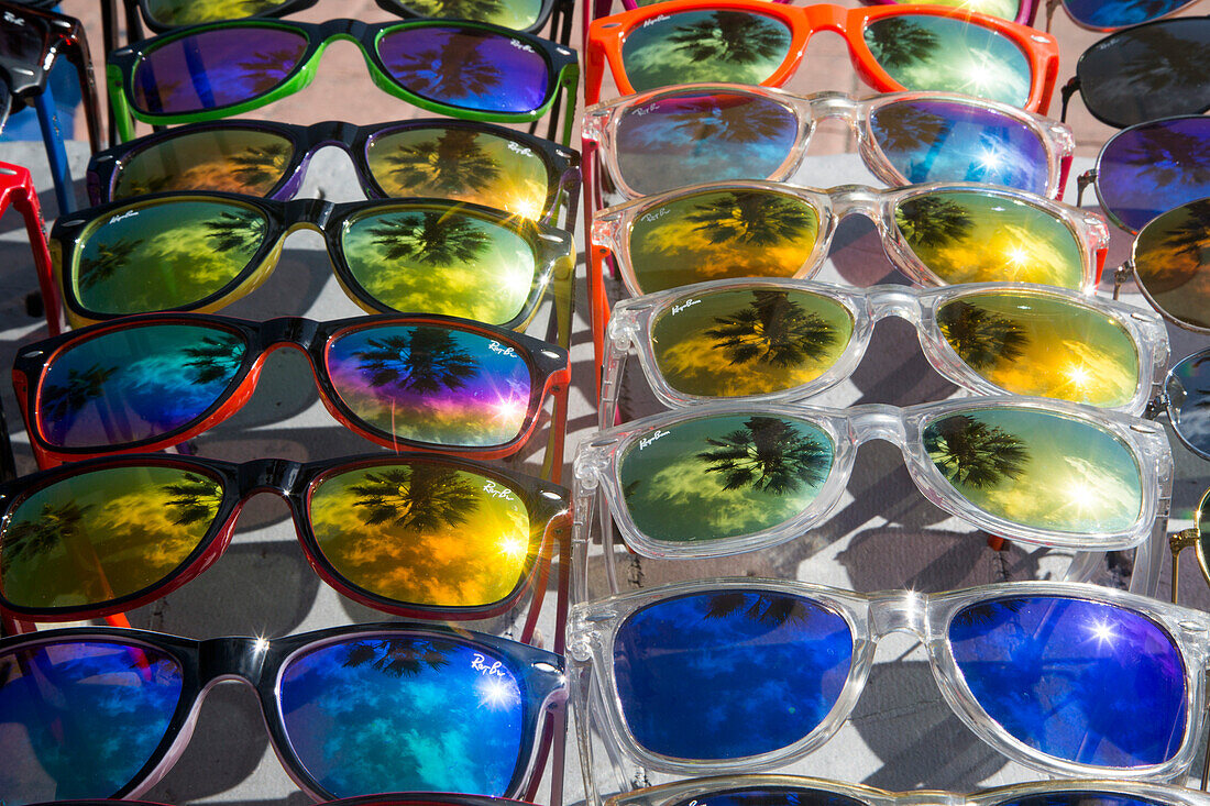 Reflection of palm trees in colorful (fake) Ray-Ban sunglasses for sale by street vendor, Alicante, Andalusia, Spain
