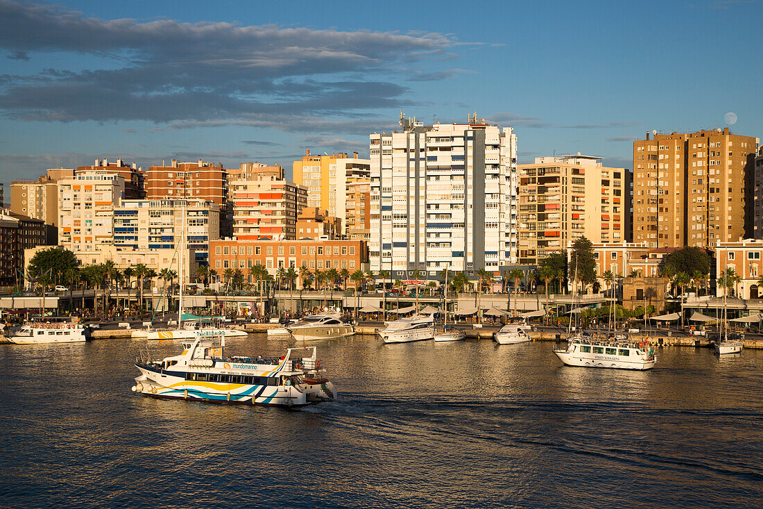 Malaga-Benalmadena ferry and sightseeing boats in harbor with high-rise apartment buildings, Malaga, Costa del Sol, Andalusia, Spain