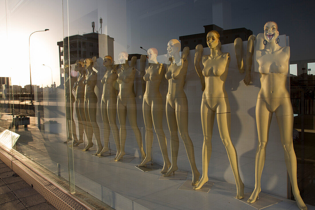 Naked mannequin figures with separated arms in window of empty clothes shop, Larnaca, Larnaca, Cyprus