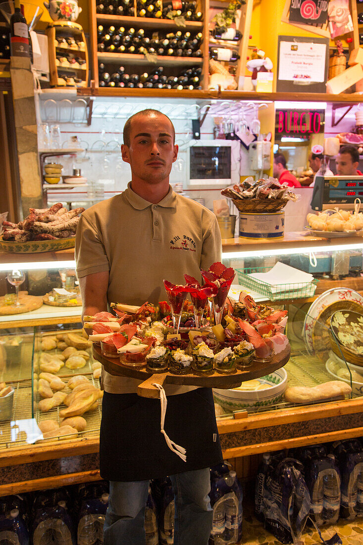 Kellner serviert opulente Platte mit absolut köstlichen Antipasti im Fratelli Burgio Feinkostladen und Restaurant in der Altstadt, Syrakus, Sizilien, Italien, Europa