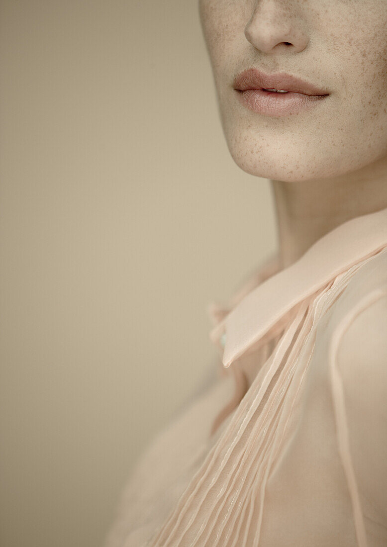 Woman wearing blouse, close-up of lower face and chest