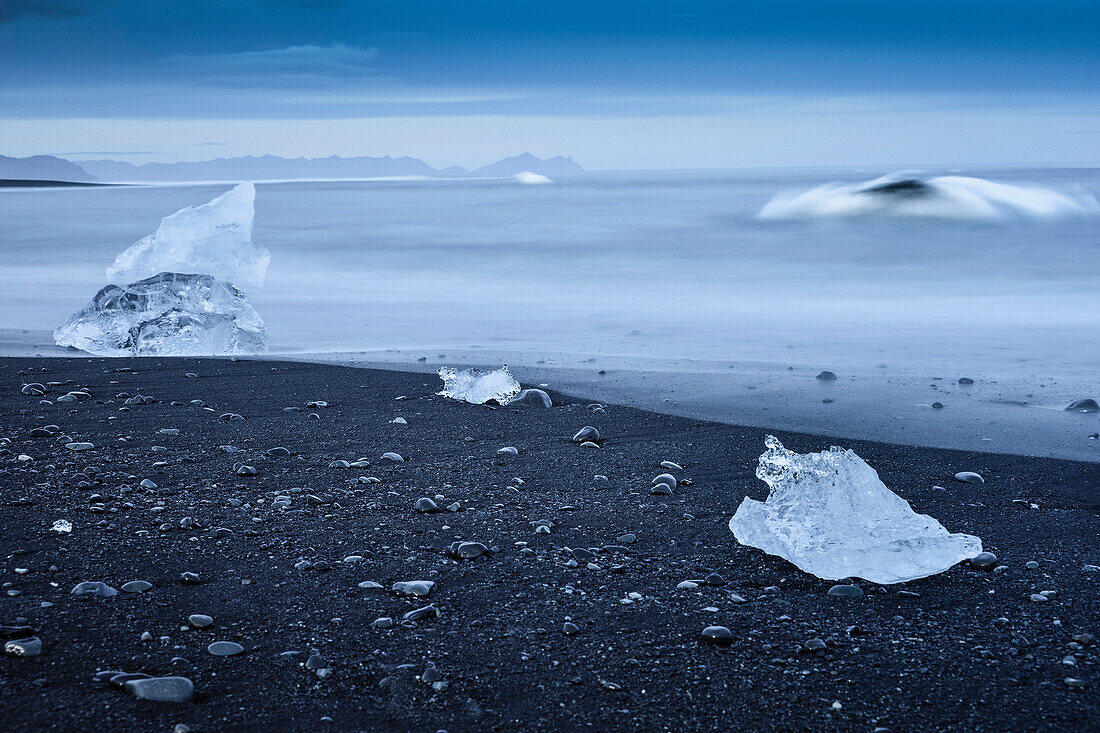 Blue Icebergs and drift ice at black lava beach from glacier lake Jokulsarlon at Vatnajökull near Skaftafell National Park, East Iceland, Iceland, Europe