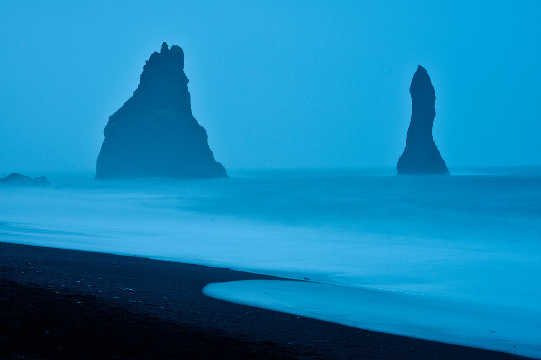 Basaltformationen Reynisdrangar  im Meer, Schwarzer Lavastrand an der Küste von Vik I Myrdal, Südisland, Island, Europa