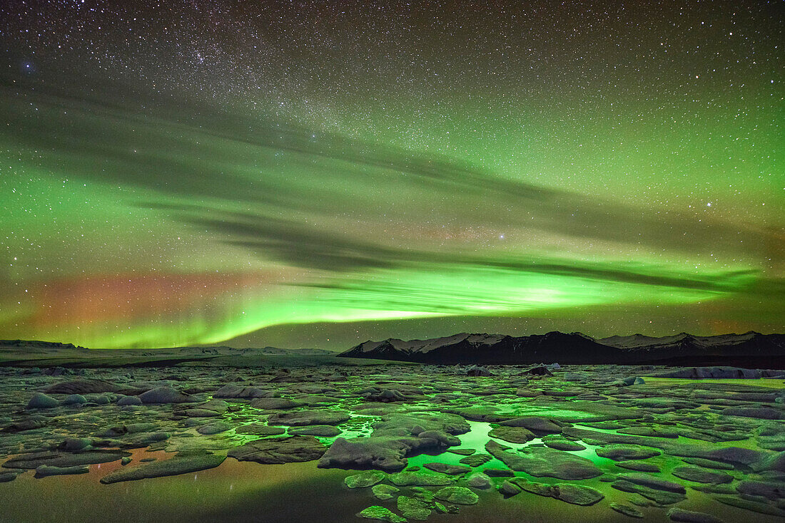 Multicolored northern lights (aurora borealis) over glacial lake Jokulsarlon and icebergs at Vatnajokull,  Breidamerkursandur between Skaftafell National Park und Hofn, East Iceland, Iceland, Europe