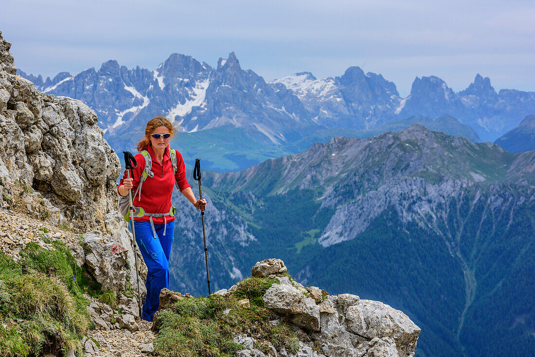 Woman hiking ascending towards Latemarspitze, Pala in background, Latemarspitze, Latemar, UNESCO world heritage Dolomites, Dolomites, Trentino, Italy