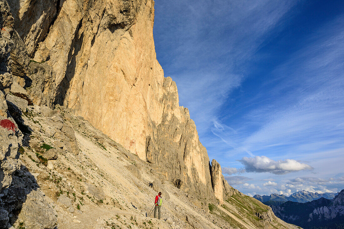Frau beim Wandern blickt zu Felswand hinauf, Rotwand, Rosengarten, UNESCO Weltnaturerbe Dolomiten, Dolomiten, Trentino, Italien