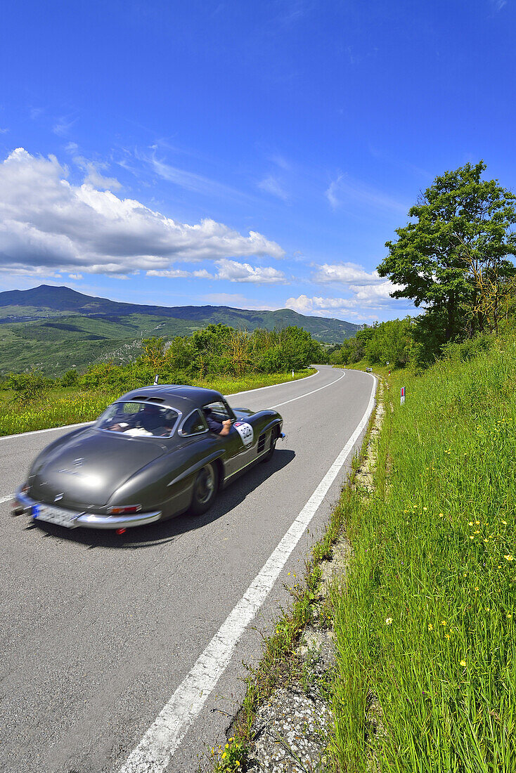 Mercedes Benz 300 SL W 198, Gullwing, Flügeltürer, Oldtimer, auf Straße in Hügellandschaft, Oldtimer, Rennwagen, Autorennen, Mille Miglia, 1000 Miglia, bei Radicofani, Toskana, Italien