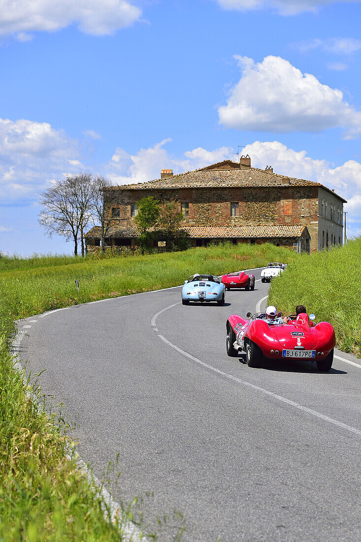Red Maserati Oldtimer on a road near a house through the Tuscan valley, Mille Miglia, 1000 Miglia, 2014, San Quirico D´orcia, Siena, Tuscany, Italy, Europe