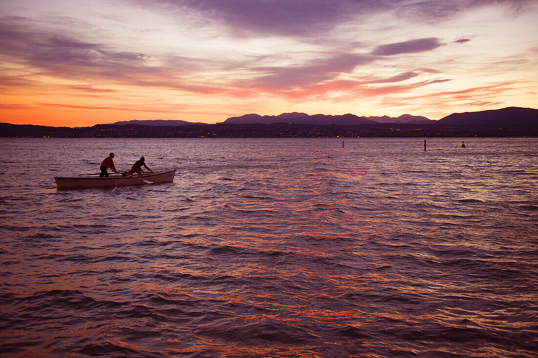 Boot, Fischerboot im Sonnenuntergang bei Sirmione mit Blick auf Desenzano del Garda, Lombardia, Italien, Europa