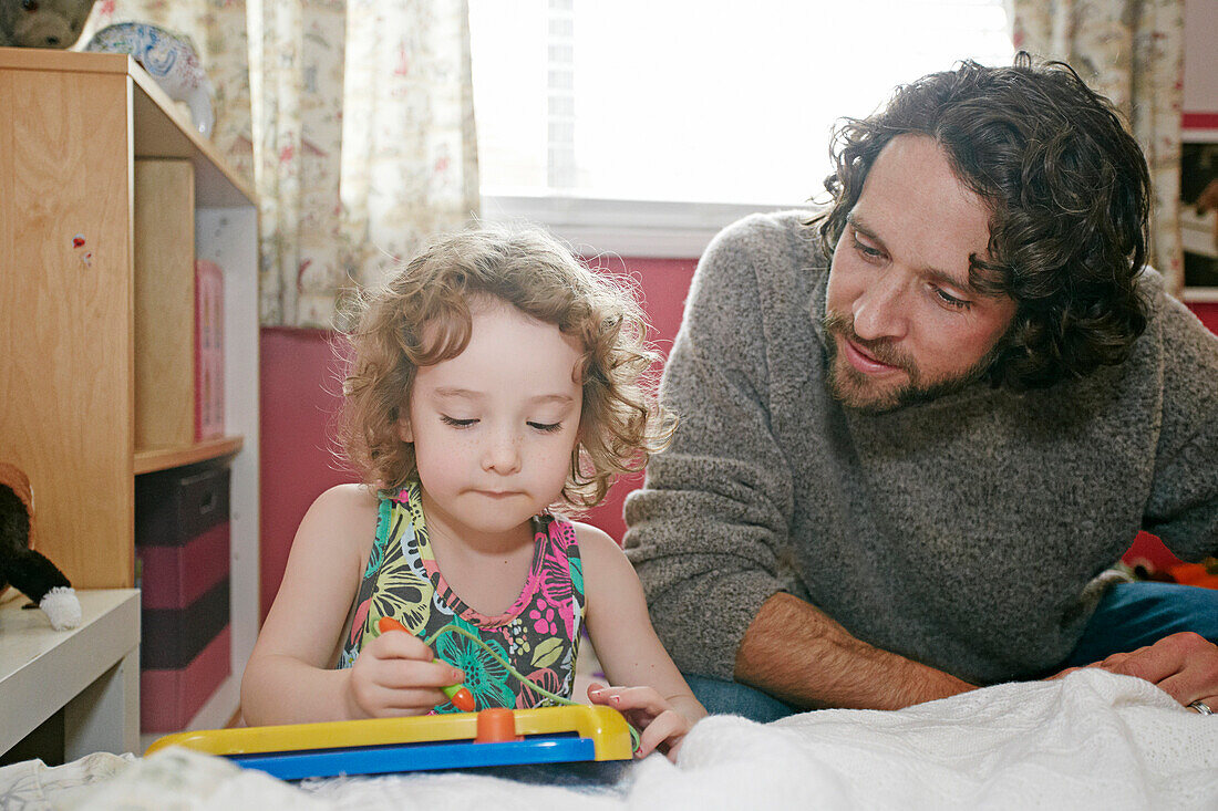 Caucasian father and daughter playing in bedroom, Los Angeles, California, USA