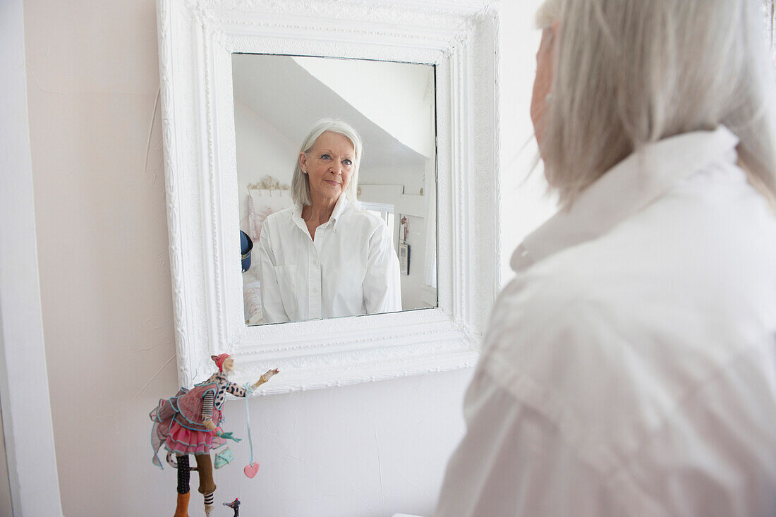 Senior Caucasian woman admiring herself in mirror, Toronto, Ontario, Canada