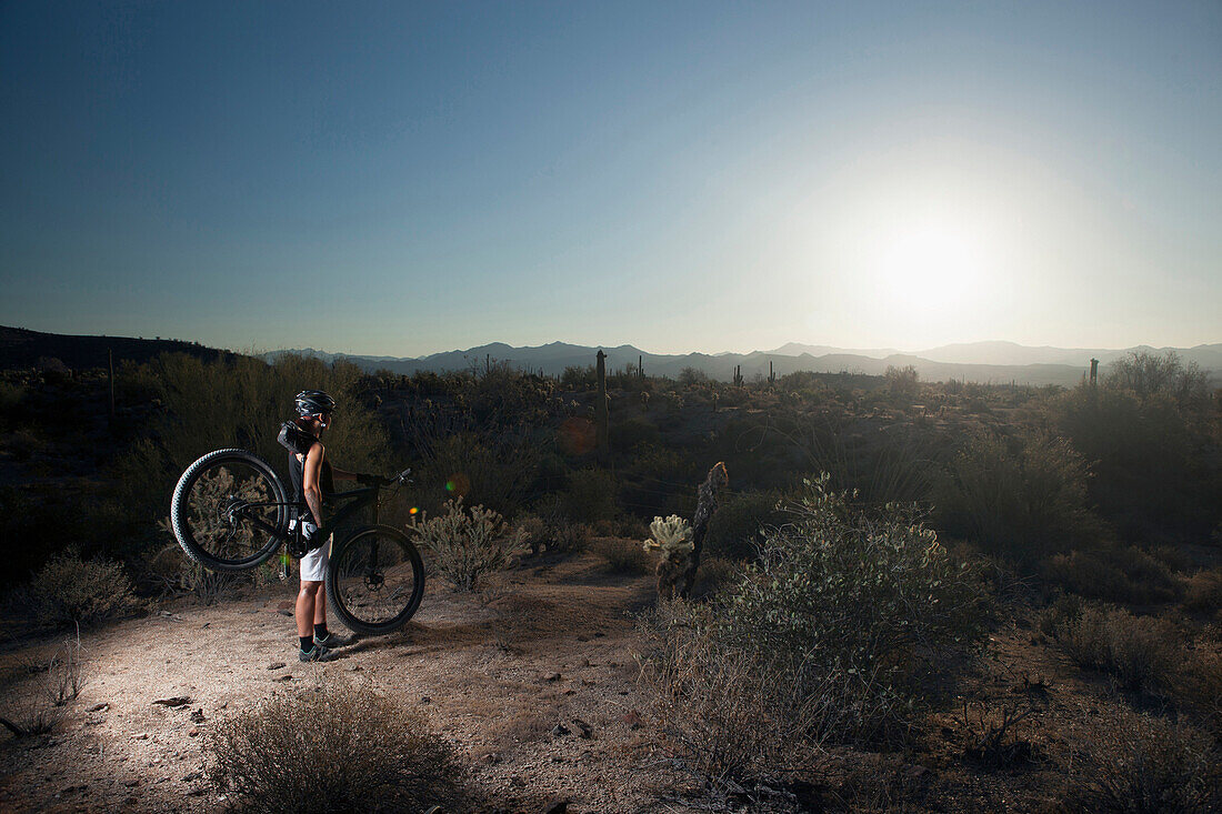 Mountain biker standing in desert, Fountain Hills, Arizona, USA