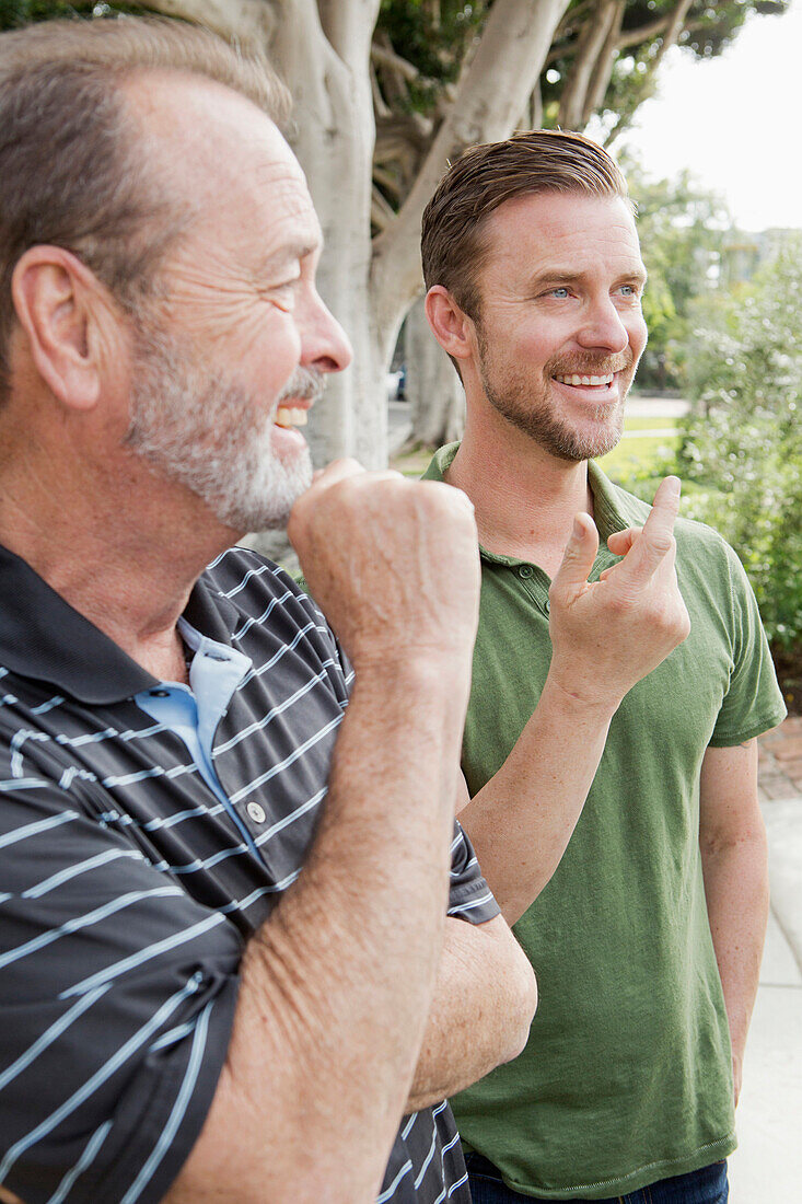 Older Caucasian man relaxing with son outdoors, Los Angeles, CA, USA