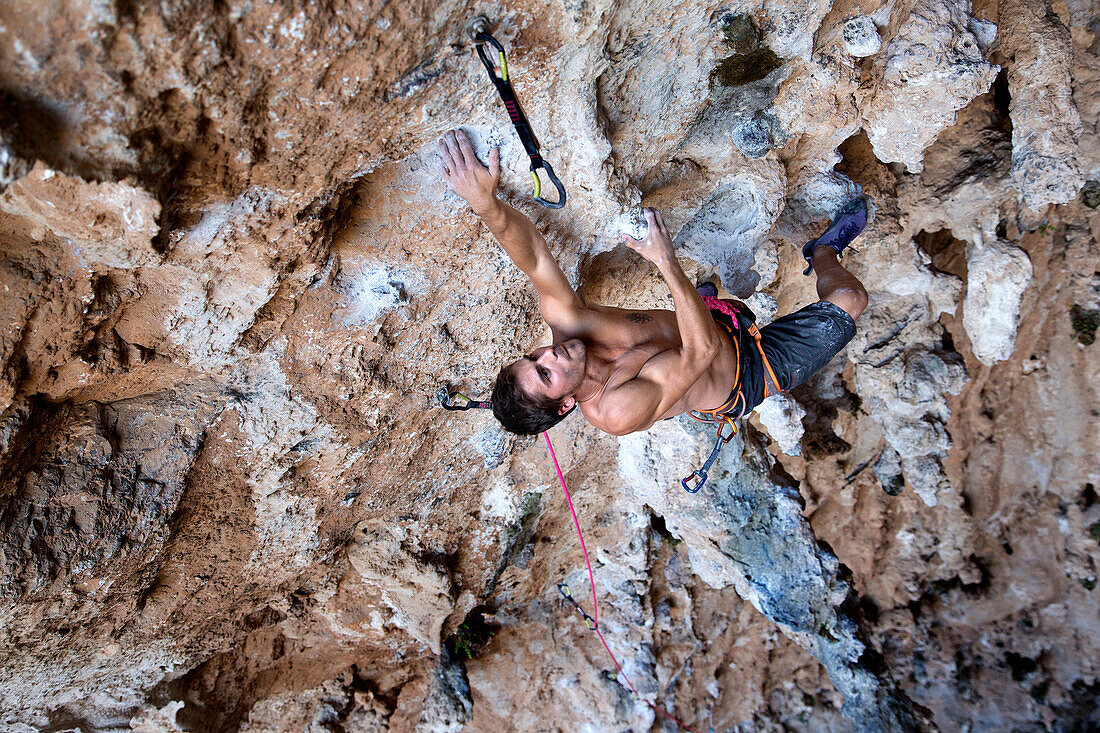 Climber hanging from rocky cave ceiling, Kalymnos, Dodecanese , Greece