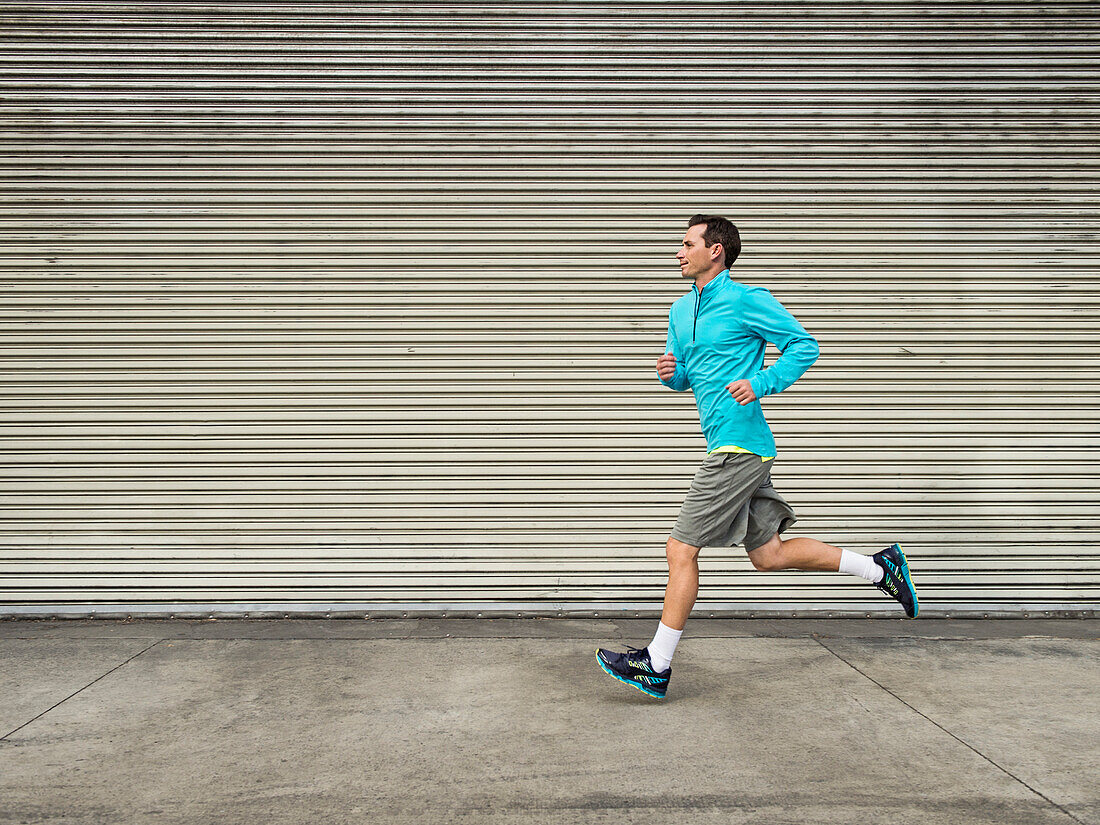 Caucasian man running on city street, Los Angeles, California, USA