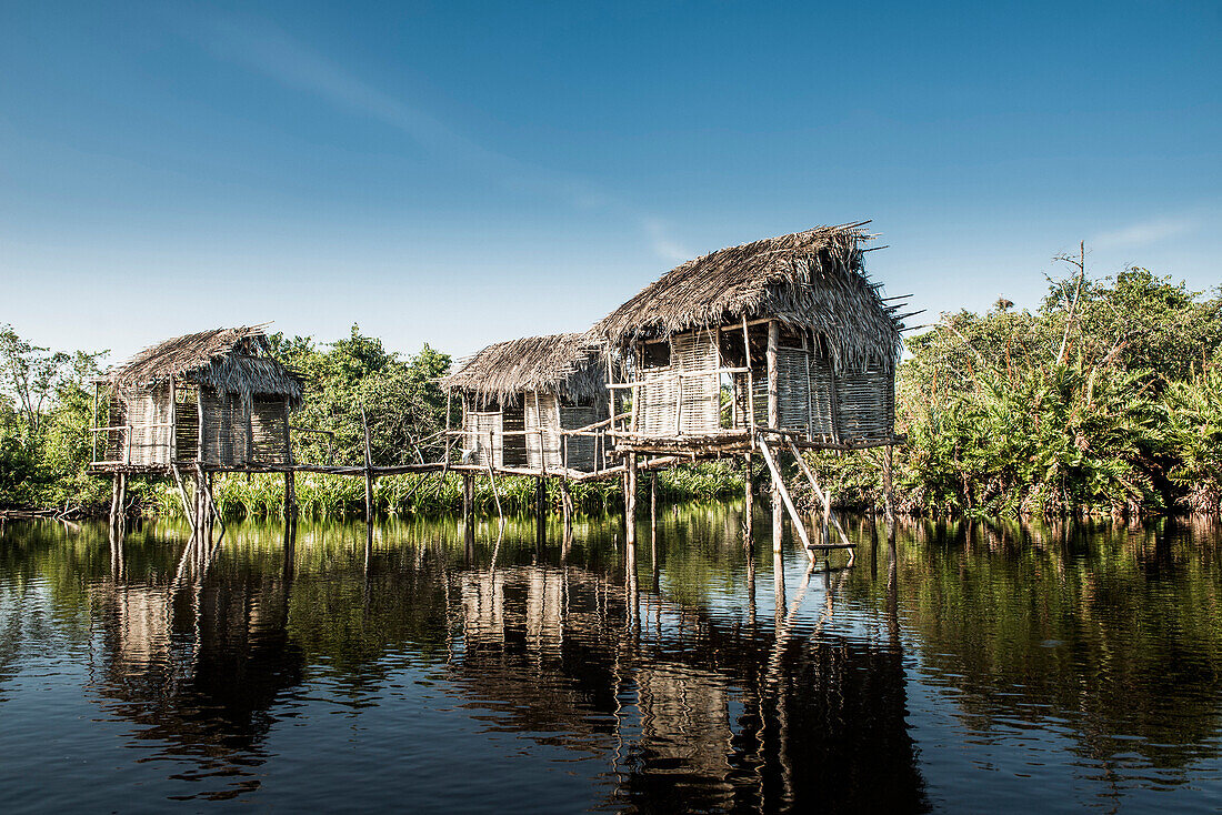 Thatch houses built over rural lake, Riviera Nayarit, Nayarit, Mexico