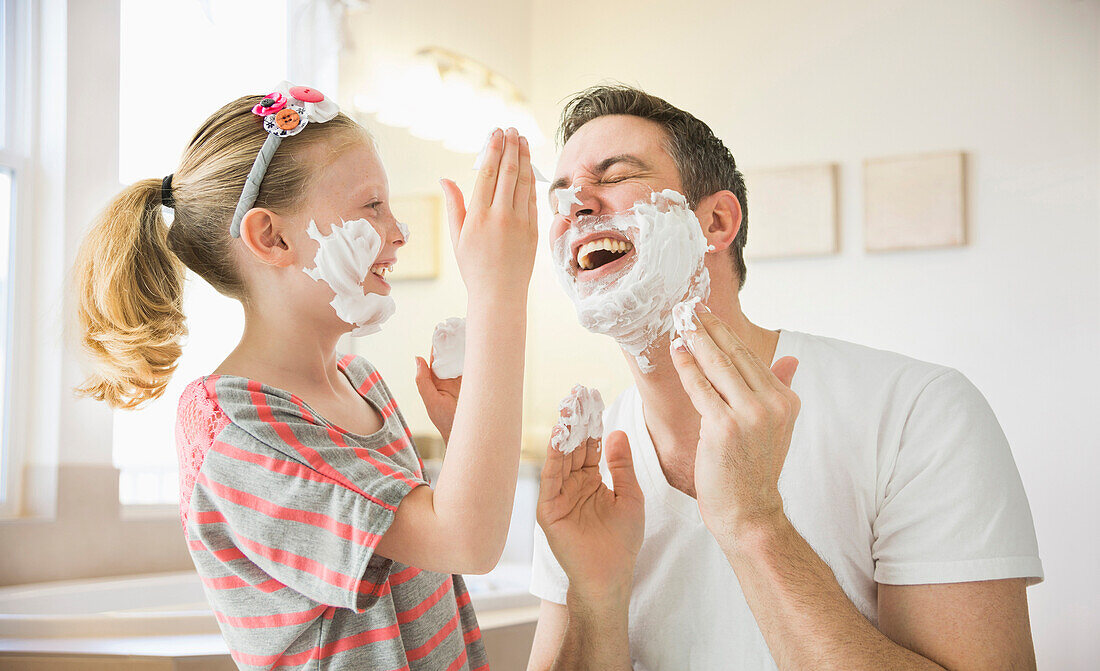 Caucasian father and daughter playing with shaving cream, Lehi, Utah, USA