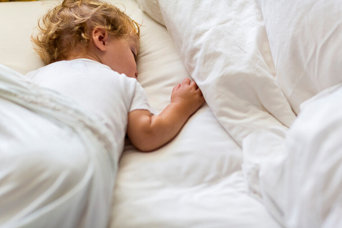 Caucasian toddler asleep in bed, Santa Fe, New Mexico, USA