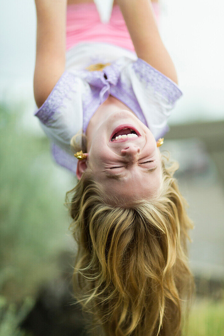 Caucasian girl hanging upside down outdoors, Santa Fe, New Mexico, USA