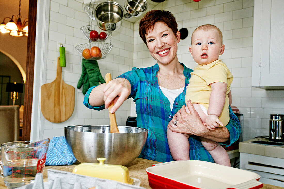 Caucasian mother cooking with baby in kitchen, C1