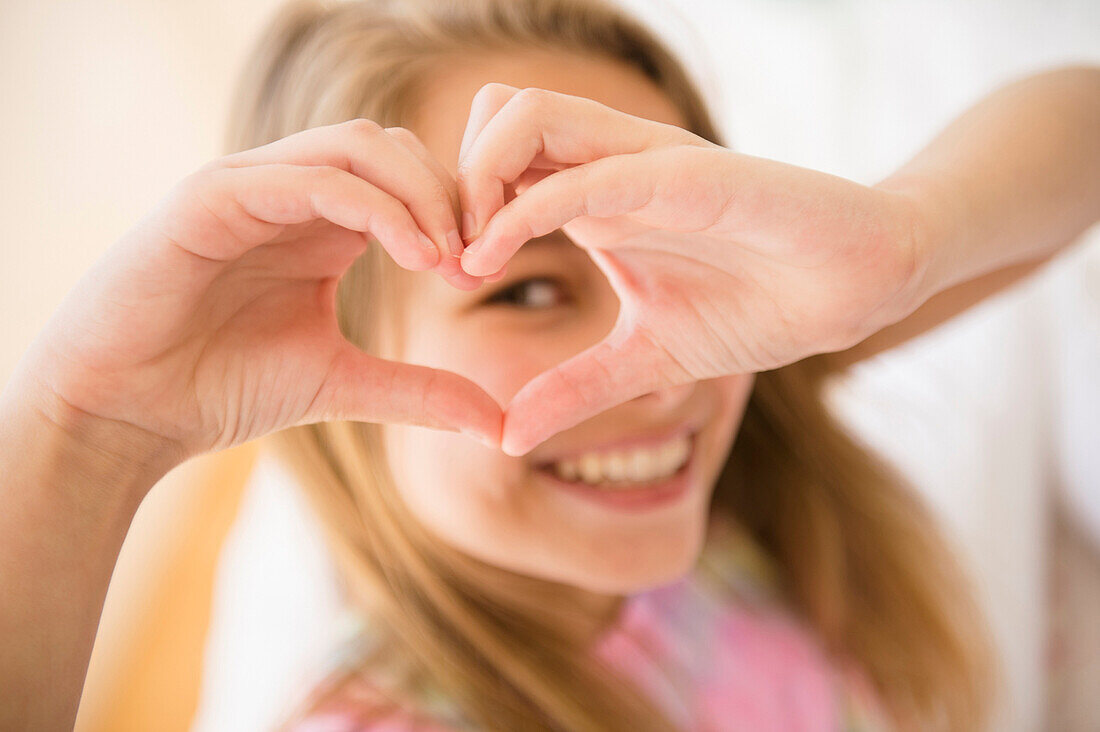 Caucasian girl making heart shape with hands, Jersey City, New Jersey, USA