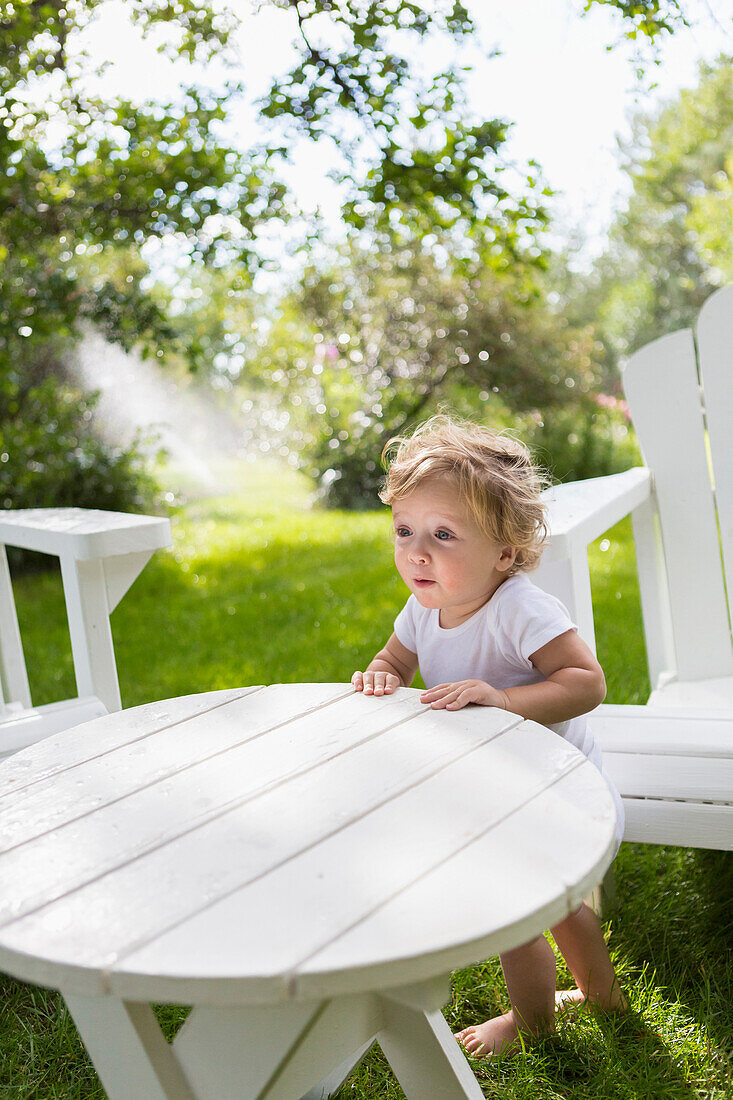 Caucasian baby boy sitting at table in backyard, Hesperus, Colorado, USA