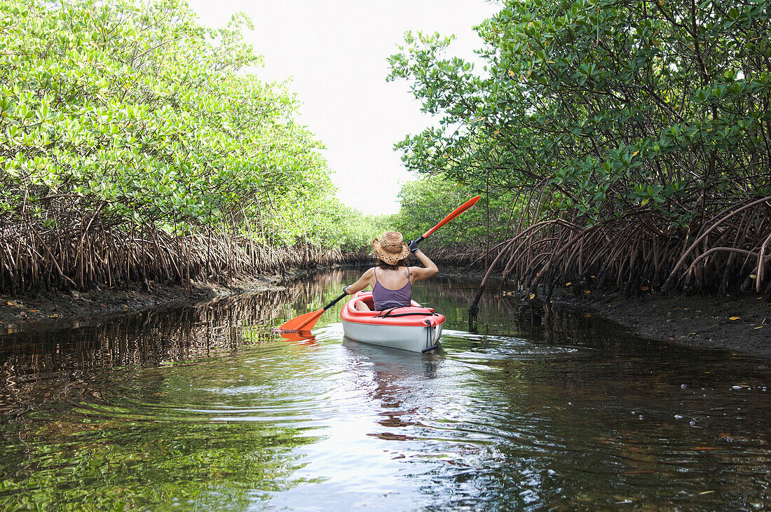 Mixed race woman kayaking in river, Miami, Florida, United States