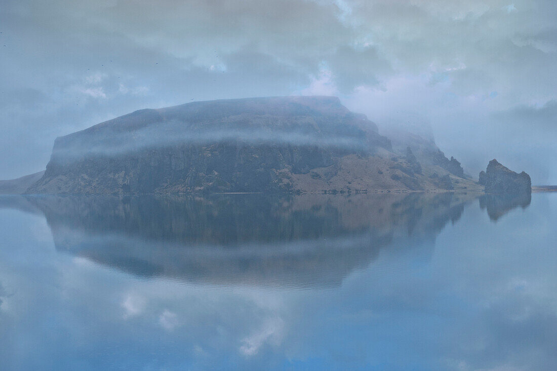 Snowy mountain under cloudy sky reflected in lake, Vik, Sudhurland, iceland