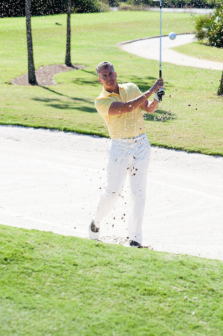 Caucasian man golfing from sand trap on golf course, Palm Beach, Florida, USA