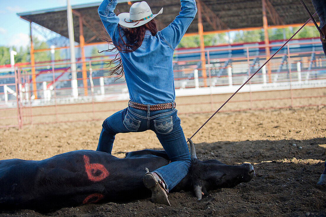 Caucasian cowgirl tying cattle in rodeo on ranch, Joseph, Oregon, USA