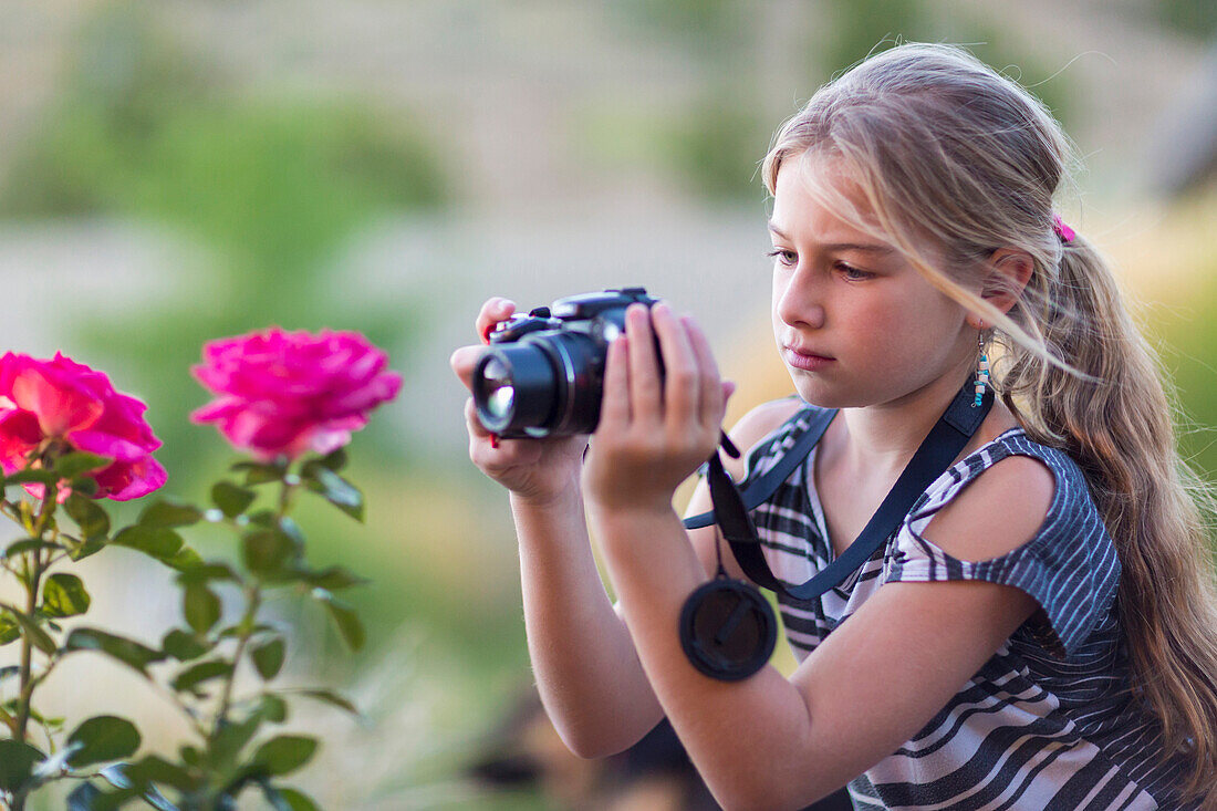 Caucasian girl photographing flowers outdoors, Santa Fe, New Mexico, USA
