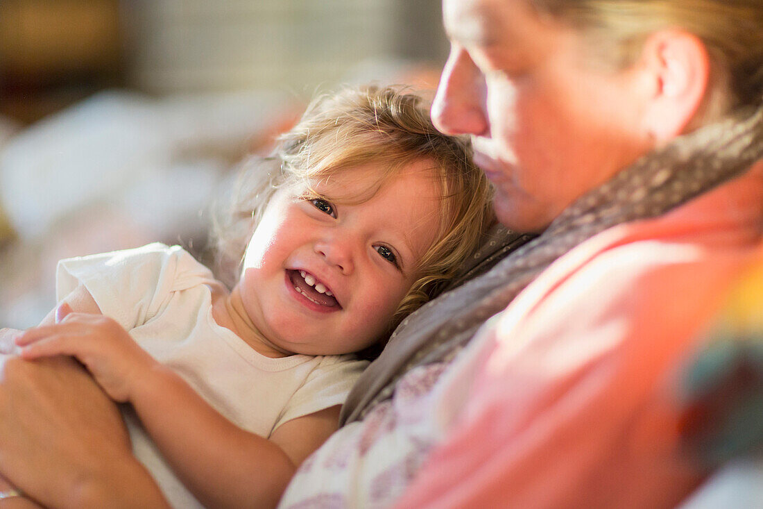 Caucasian mother and baby son cuddling on sofa, Santa Fe,  New Mexico, USA