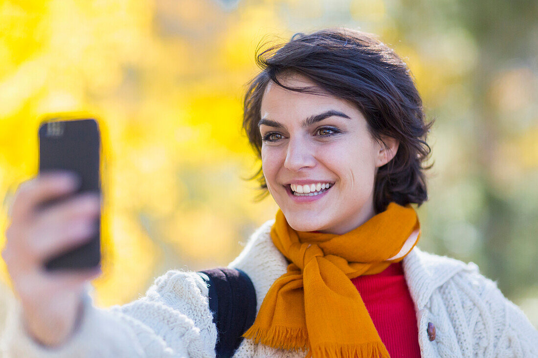 Mixed race woman taking cell phone selfie outdoors, Santa Fe, New Mexico, USA