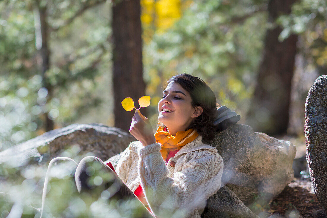 Mixed race woman admiring autumn leaves in forest, Santa Fe, New Mexico, USA