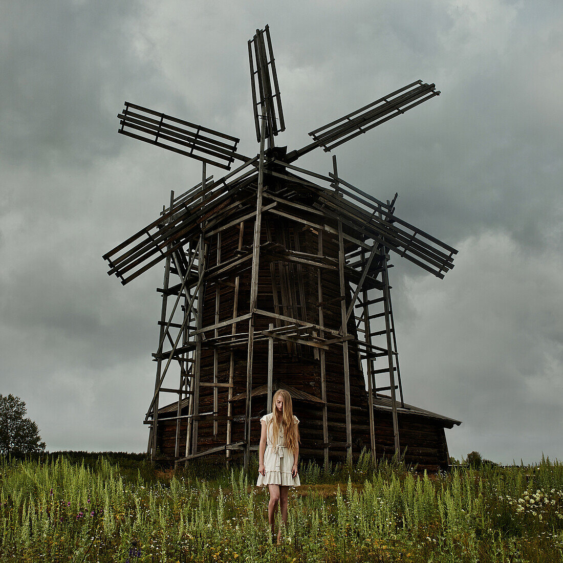 Caucasian teenage girl standing under wooden windmill, Nizniy Tagil, Sverdlovsk, Russia