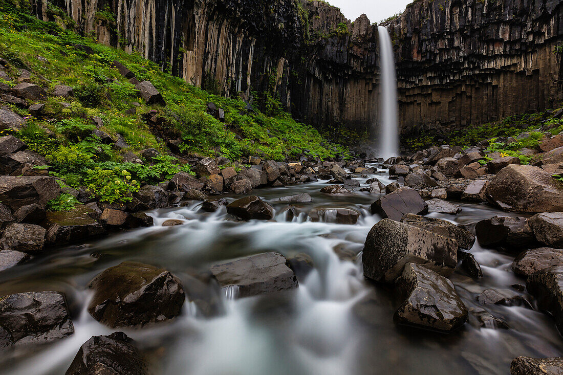 Blurred view of waterfall over rocky creek, Skaftafell, Iceland, Iceland