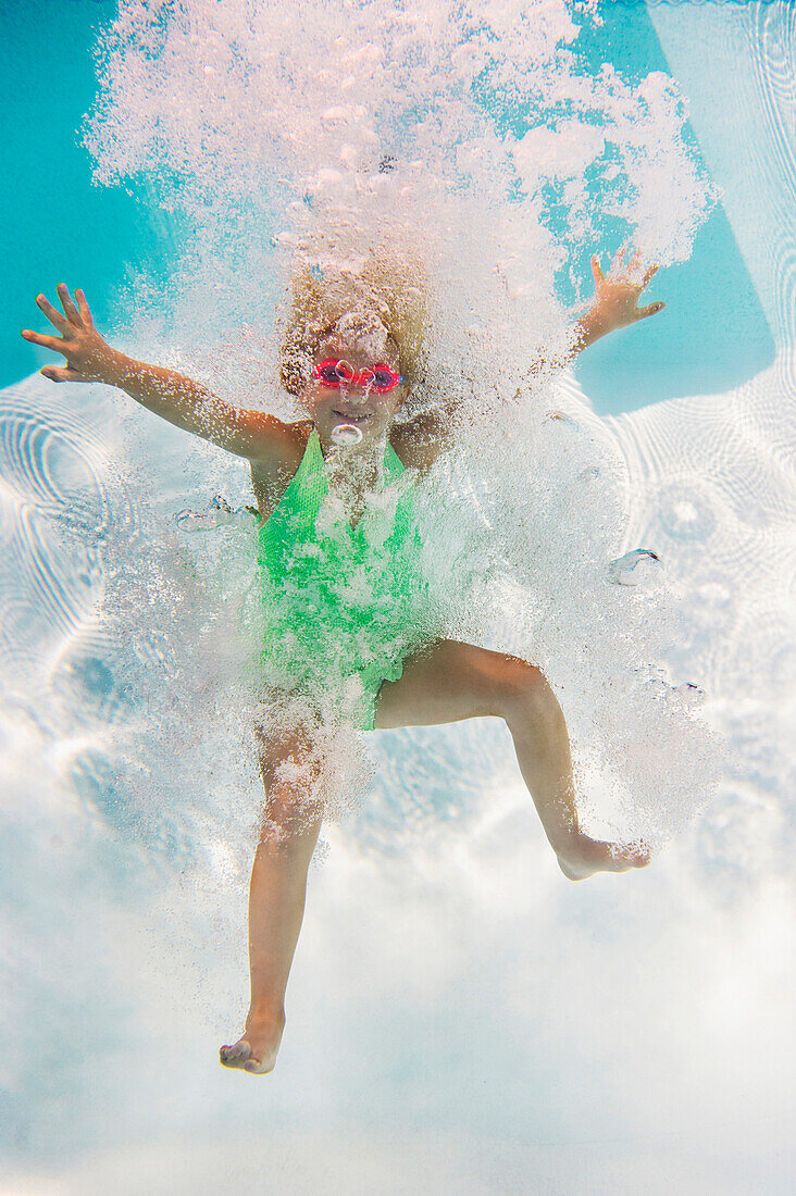 Caucasian girl swimming underwater in pool, Huntington Station, New York, USA