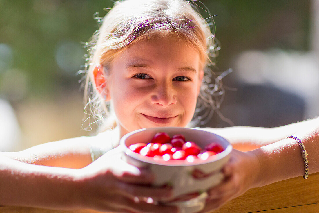 Caucasian girl holding bowl of fruit, Santa Fe, New Mexico, USA
