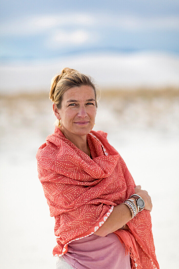 Caucasian woman smiling on sand dune, White Sands, New Mexico, USA
