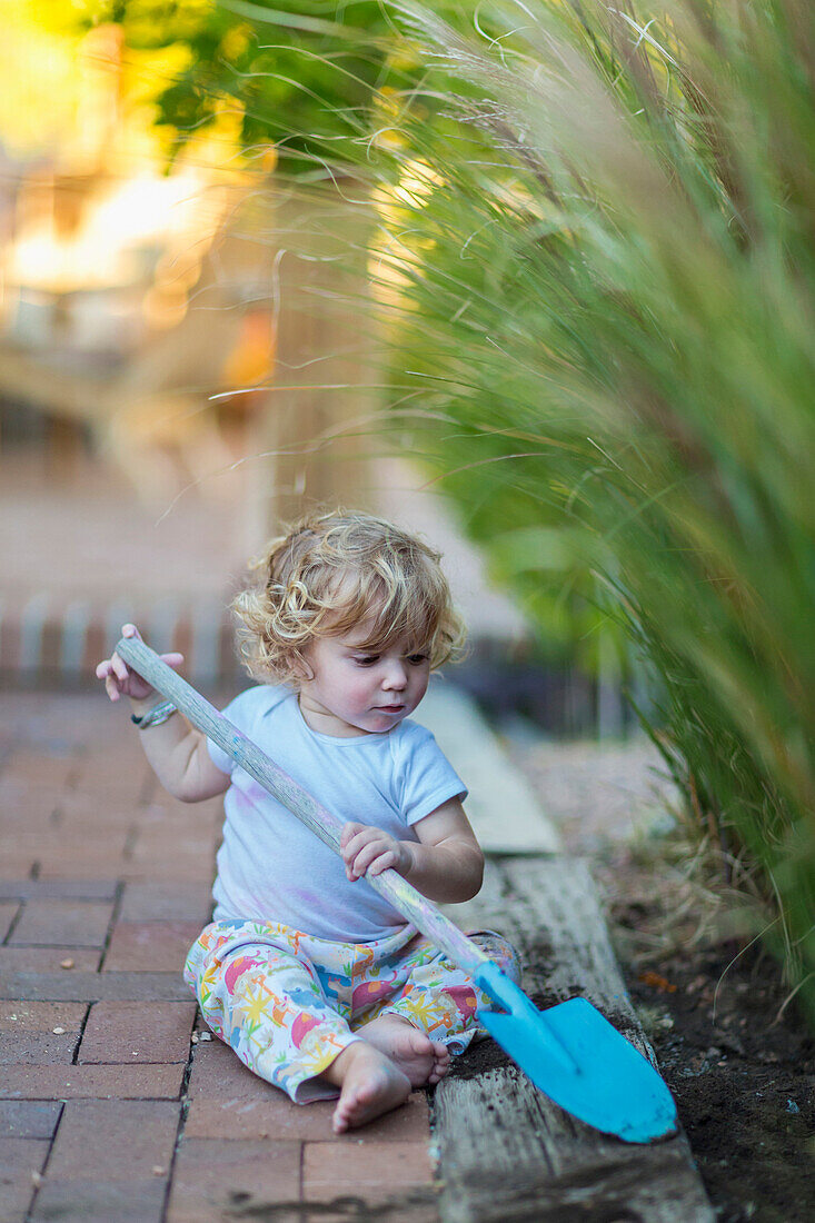 Caucasian boy playing with spade in garden, Santa Fe, New Mexico, USA