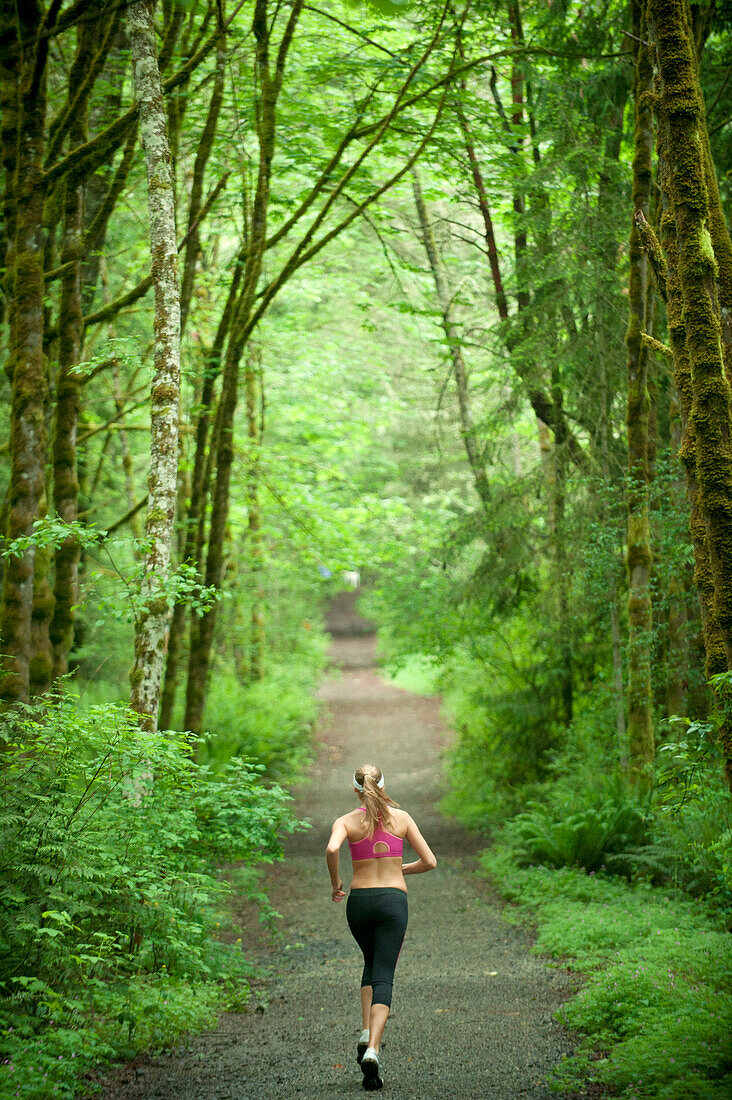 Caucasian woman running on remote path, Bainbridge Island, Wa, USA