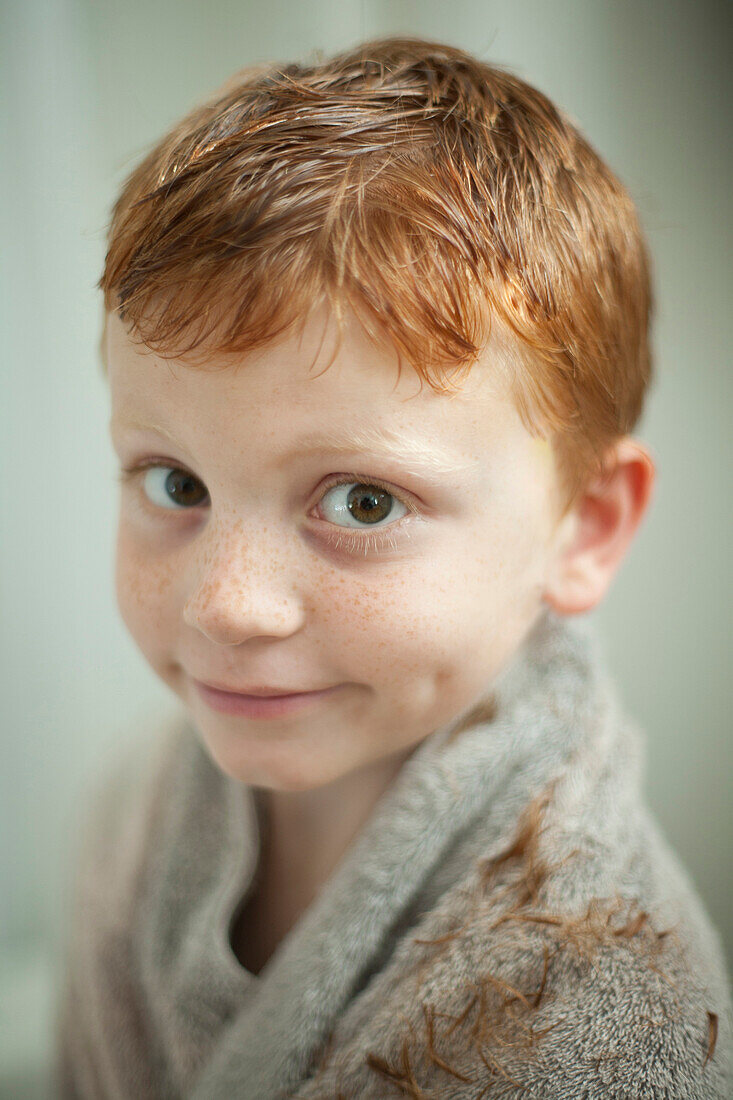 Caucasian boy wrapped in towel after haircut, Blacksburg, Virginia, United States