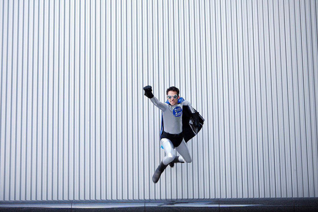 Caucasian man jumping in superhero costume, San Francisco, CA, USA