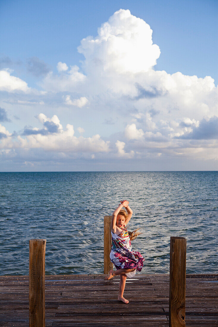 Caucasian girl dancing on pier, Florida Keys, Florida, USA